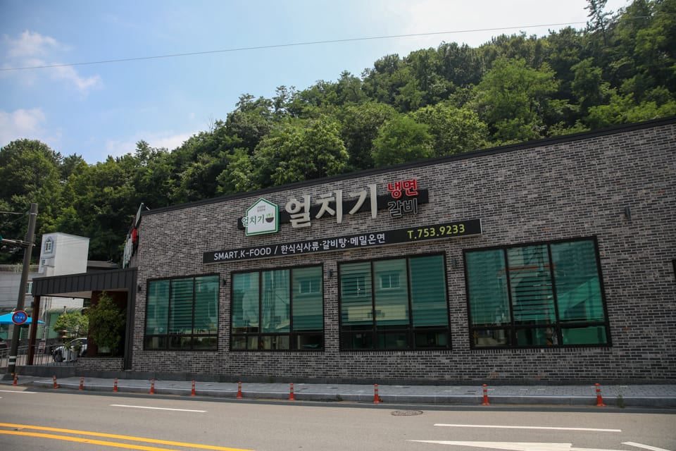 진주 얼치기 매장 입구와 전용 주차장 전경, 진주 육전냉면 안내