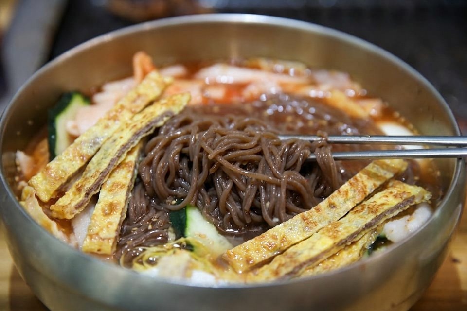 진주 얼치기 진주 물냉면 메밀순면을 드는 모습, 진주 육전냉면 안내