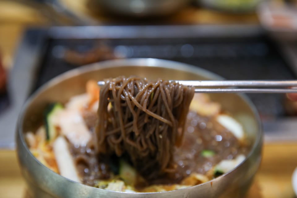 진주 얼치기 진주 물냉면 메밀순면을 드는 모습, 선주후면 안내