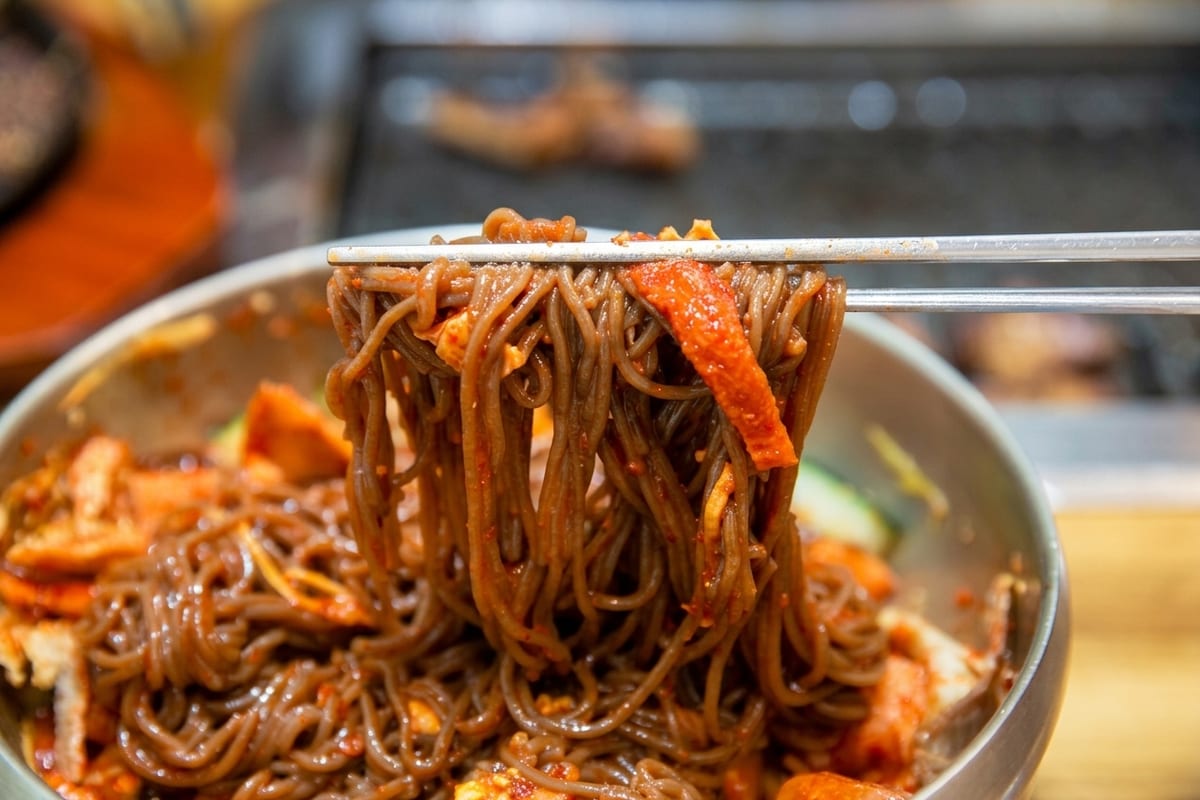 진주 얼치기 새콤한 양념의 비빔냉면을 비비는 모습, 진주 비빔냉면 안내 2번째 컷