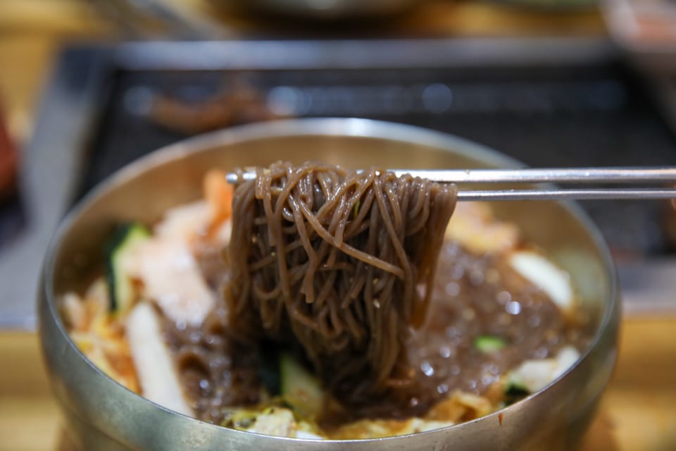 진주 얼치기 진주 물냉면 메밀순면을 드는 모습, 진주냉면 육수 안내