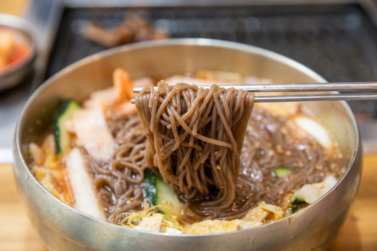 진주 얼치기 진주 물냉면 메밀순면을 드는 모습, 진주 냉면 맛집 웨이팅·주차 안내