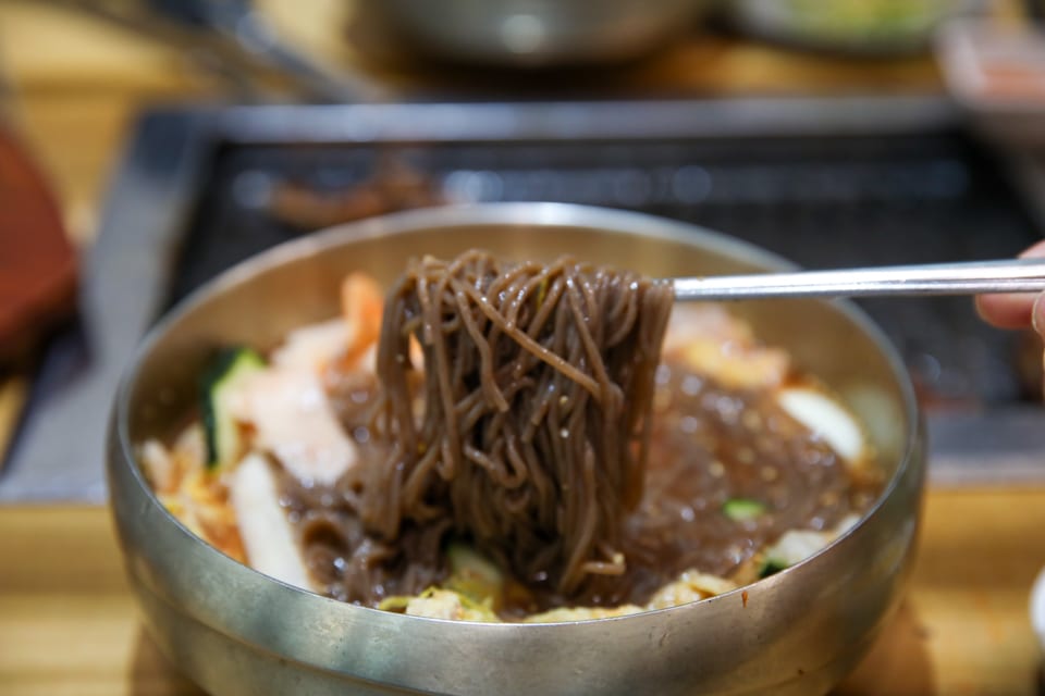진주 얼치기 진주 물냉면 메밀순면을 드는 모습, 얼치기 메뉴 안내