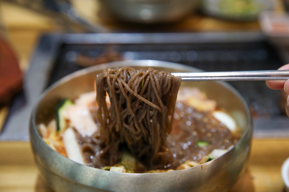 진주 얼치기 진주 물냉면 메밀순면을 드는 모습, 진주냉면 평양냉면 차이 안내