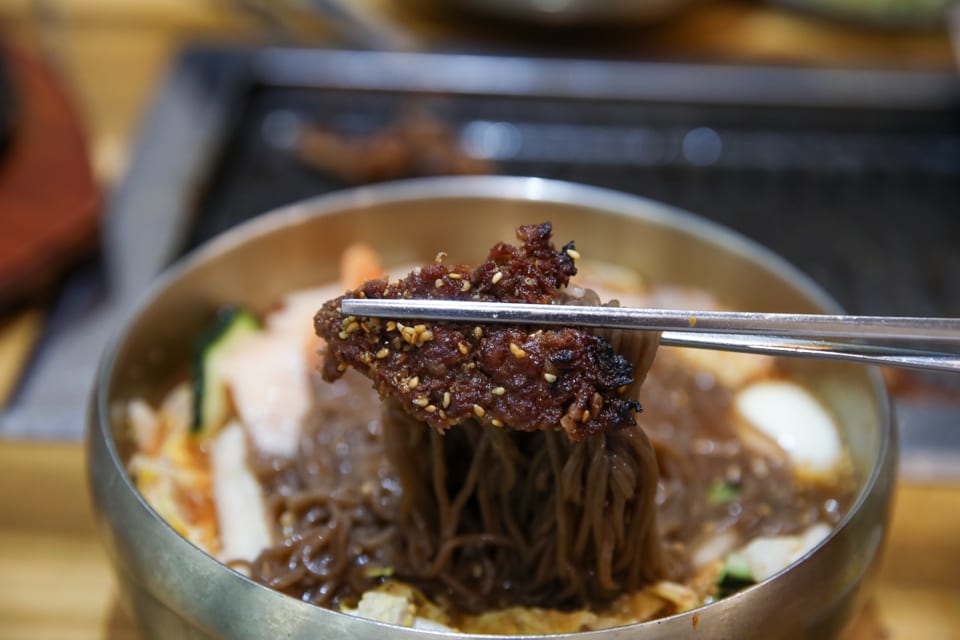 진주 얼치기 진주 물냉면 메밀순면을 드는 모습, 얼치기 뜻·성찬익수 안내 2번째 컷
